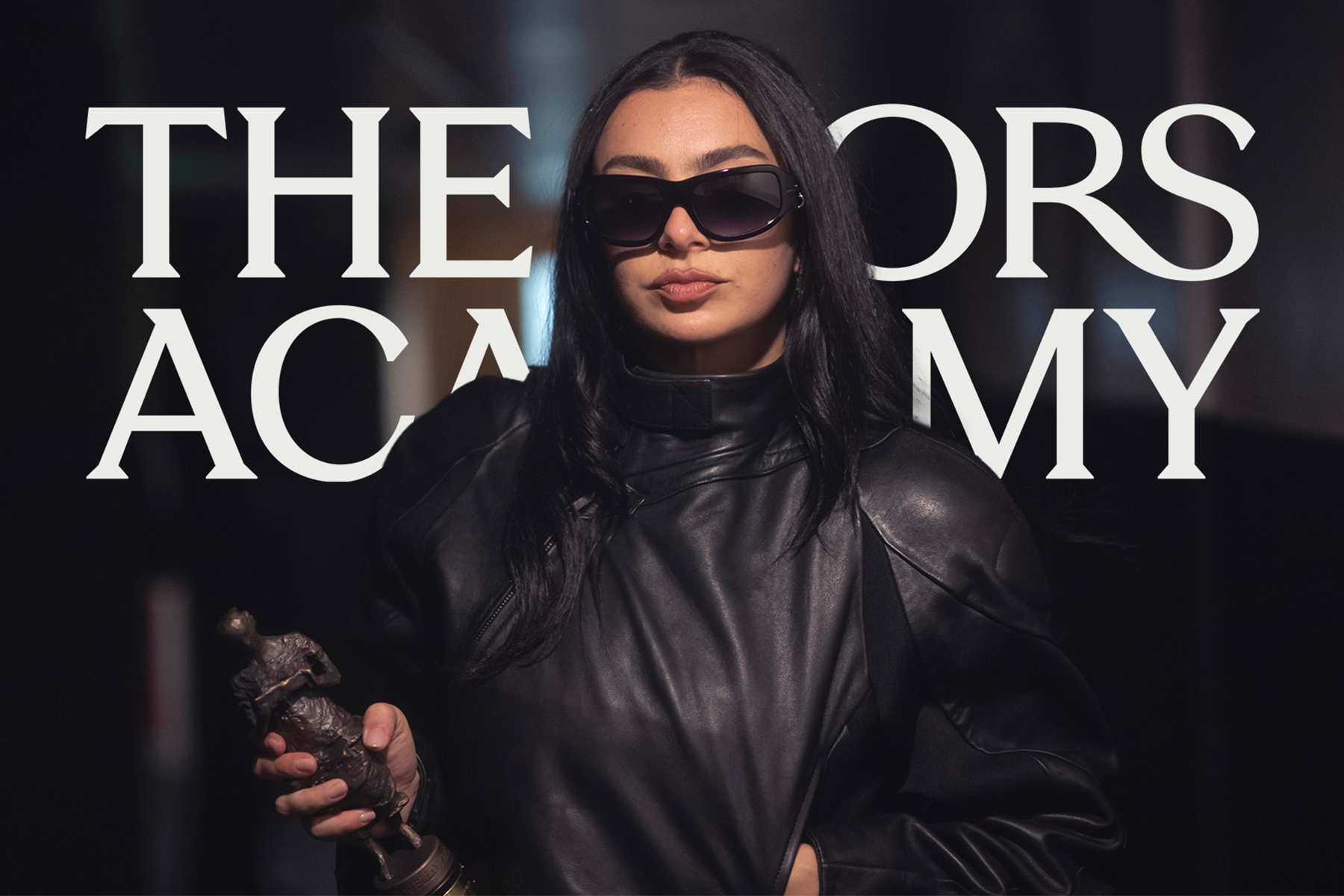 Charli xcx with an Ivor Novello Award in front of an Ivors Academy logo